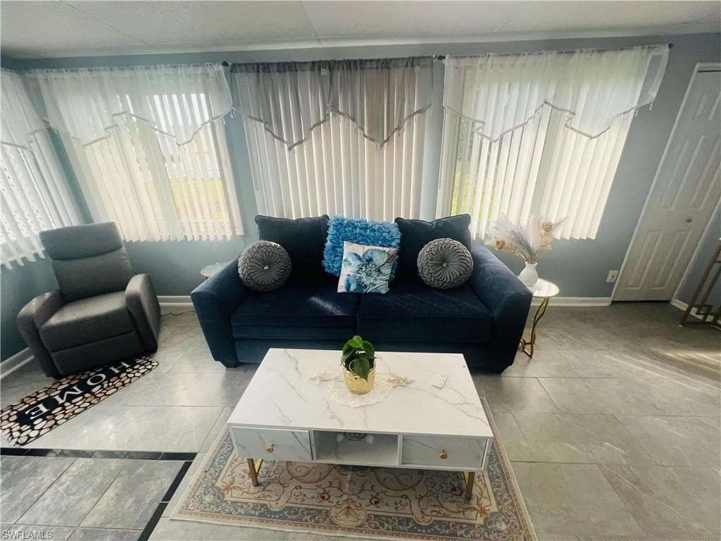 Tiled living area featuring baseboards