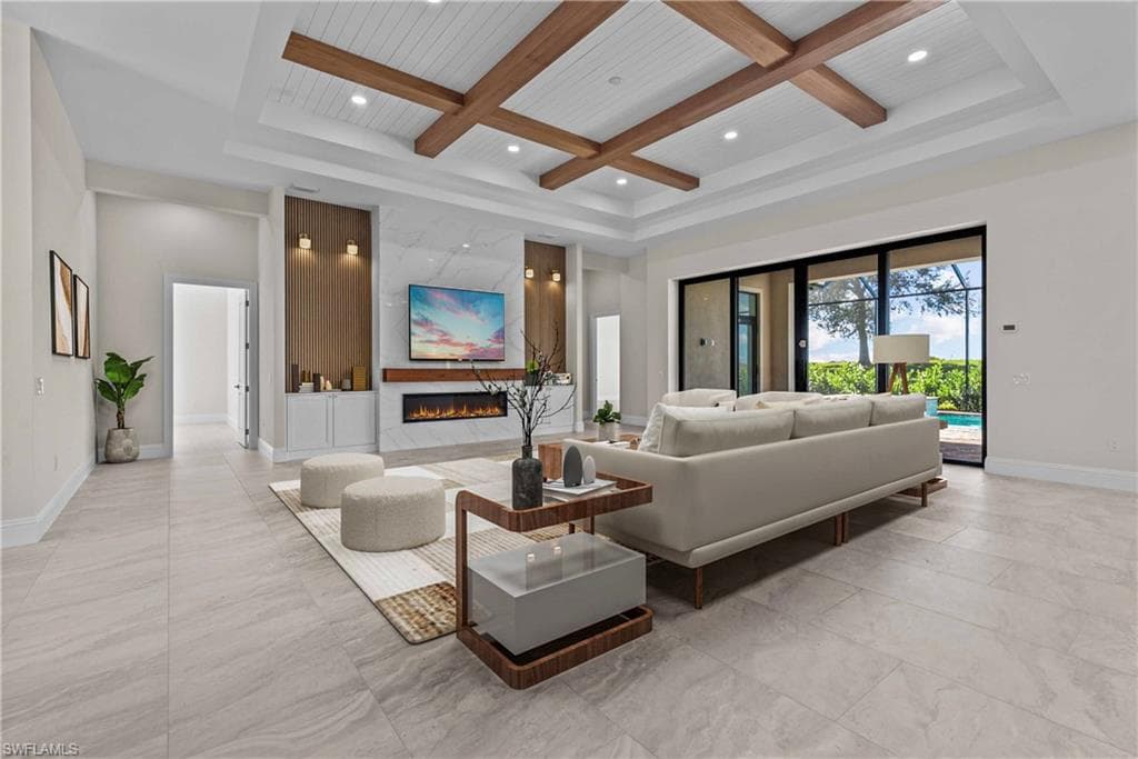 Living room with coffered ceiling, beam ceiling, a high end fireplace, and recessed lighting