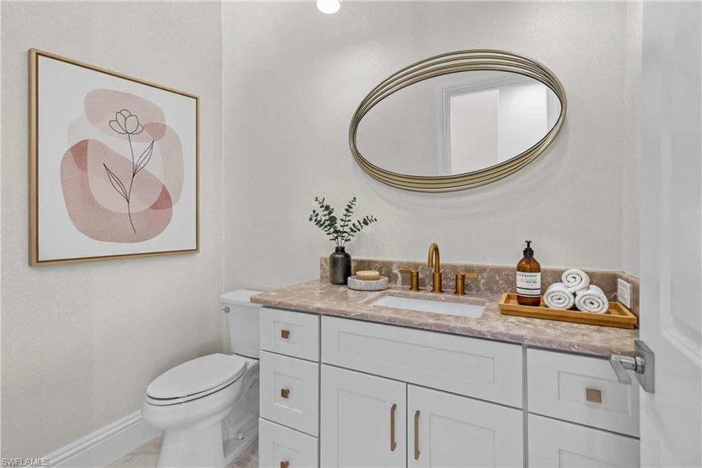 Half bathroom featuring baseboards and vanity