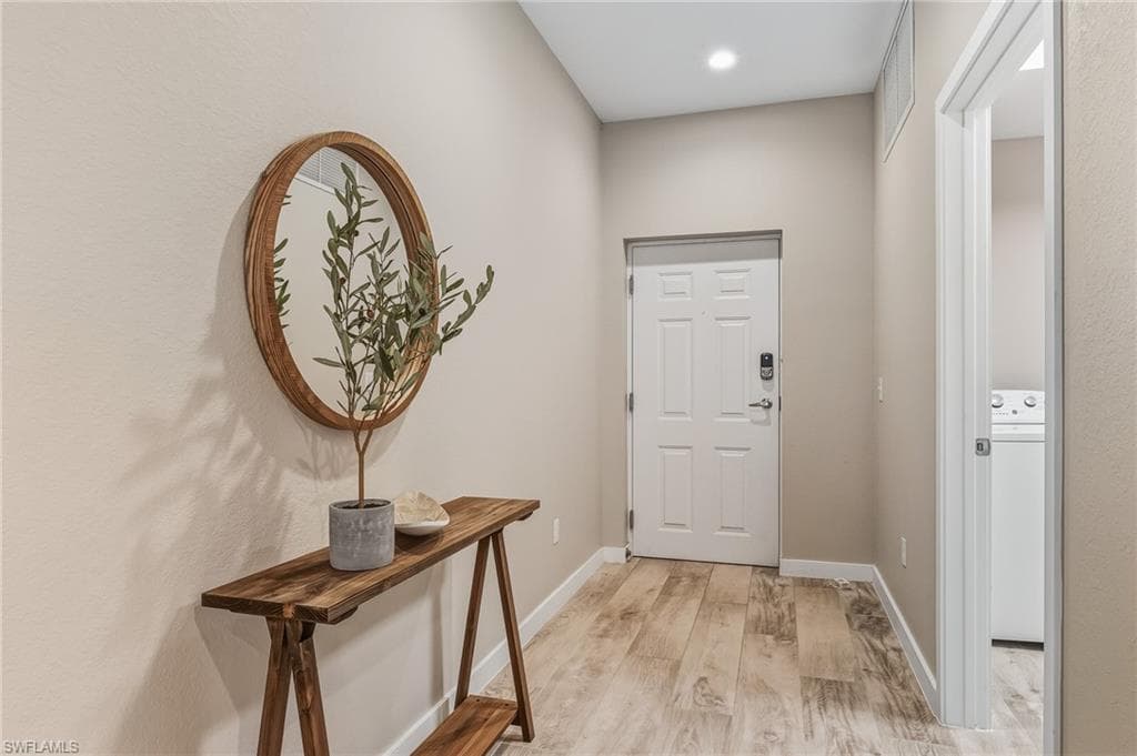 Entryway with light wood-type flooring and washer / clothes dryer