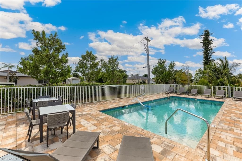 Community pool featuring a patio area and outdoor dining space