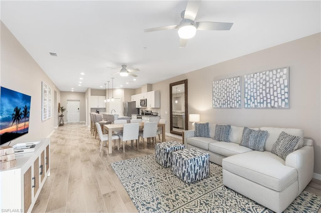 Living area with light wood-style floors, a ceiling fan, and recessed lighting