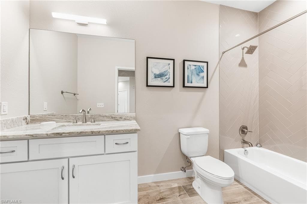 Full bathroom featuring vanity, tub / shower combination, and light wood-type flooring
