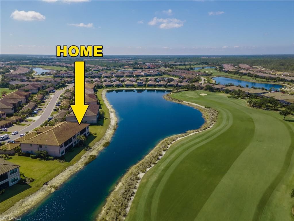 Aerial view of residential area with a nearby body of water and a golf club