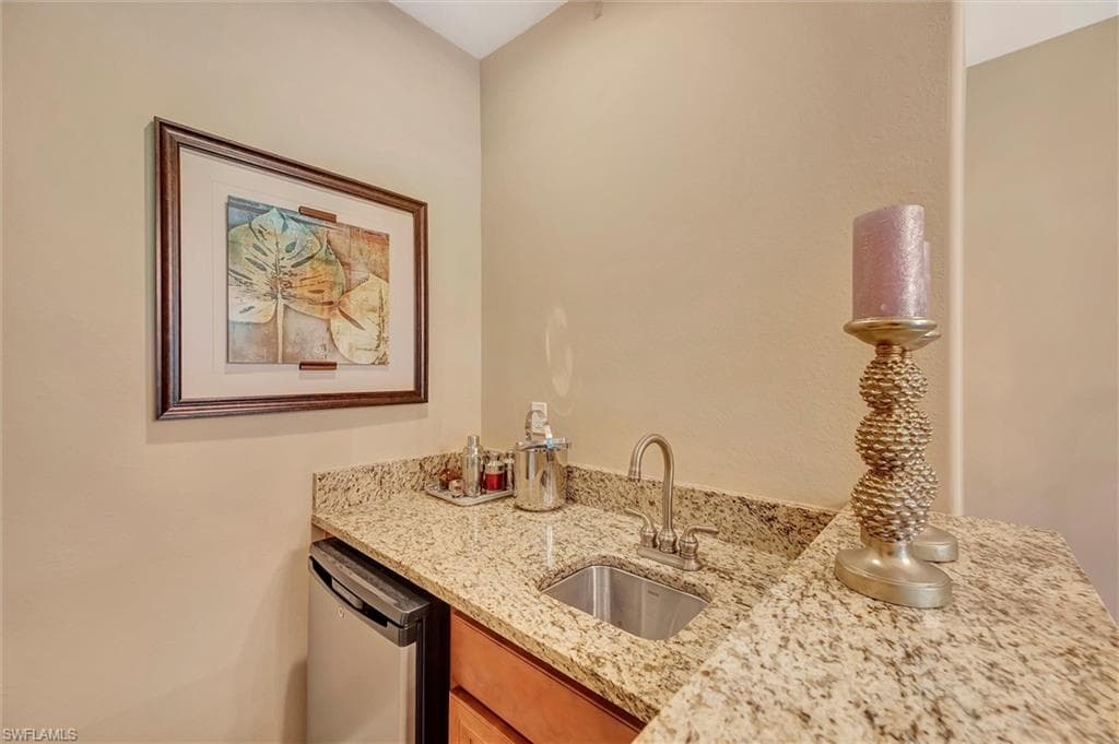 Kitchen featuring light stone countertops and stainless steel dishwasher