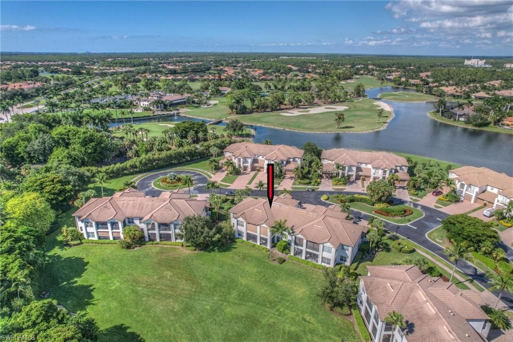 Aerial view of property's location with a large body of water, a golf club, and nearby suburban area