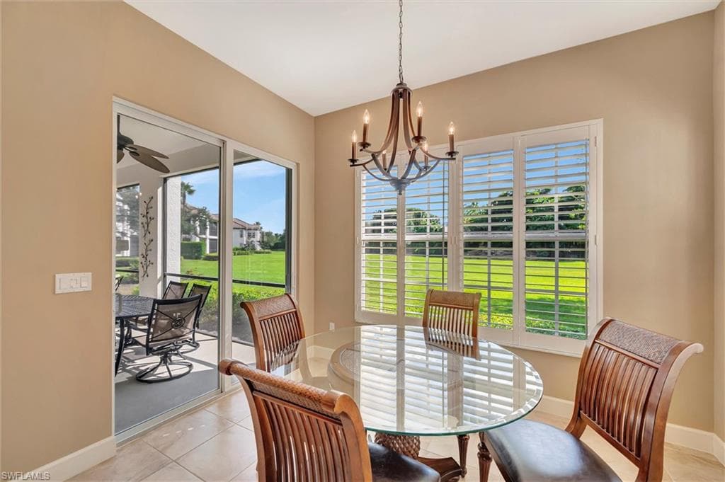 Dining room featuring light tile patterned floors, a chandelier, and a ceiling fan