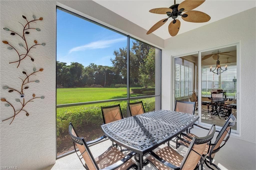 Sunroom with outdoor dining space, ceiling fan, and a chandelier