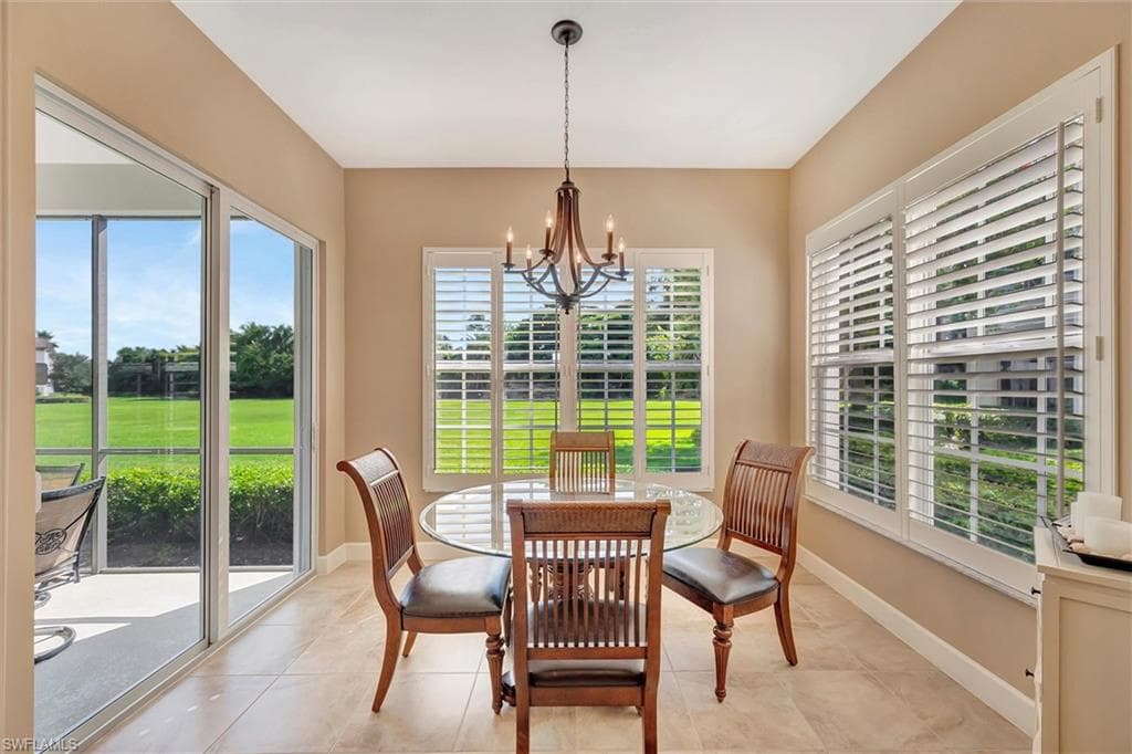 Dining area with a chandelier, plenty of natural light, and tile patterned flooring
