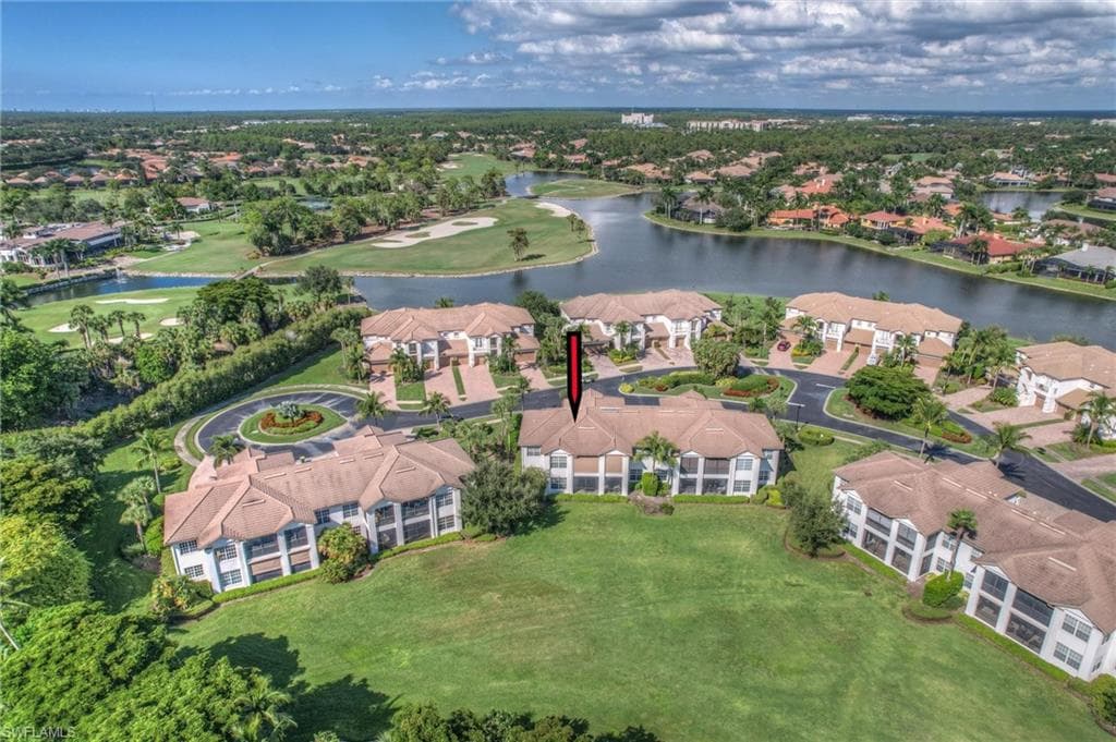 View of property location featuring a local golf course, nearby suburban area, and a nearby body of water