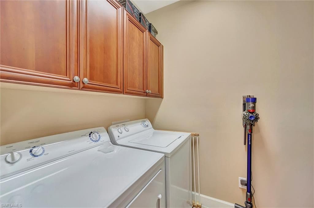 Laundry area featuring independent washer and dryer and cabinet space