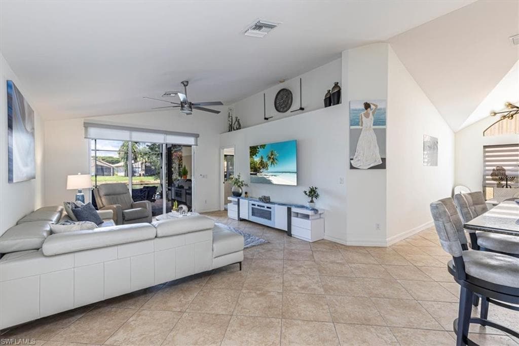 Living room featuring a ceiling fan, light tile patterned flooring, and high vaulted ceiling
