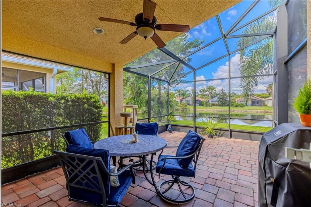 Sunroom with ceiling fan, a water view, lofted ceiling, a patio area, and outdoor dining area