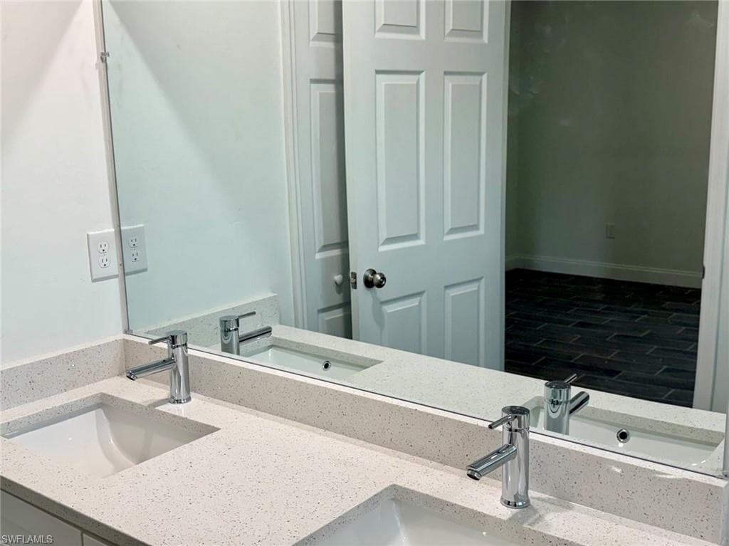 Full bathroom with double vanity and wood finished floors