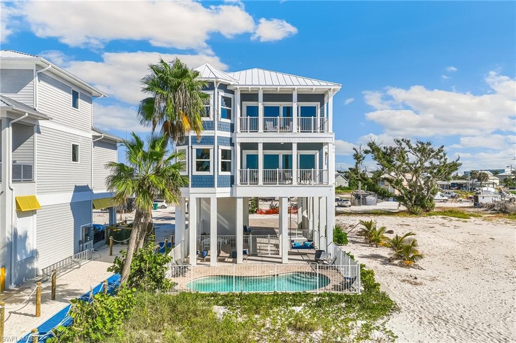 Back of property featuring a standing seam roof, a metal roof, a patio area, and a balcony