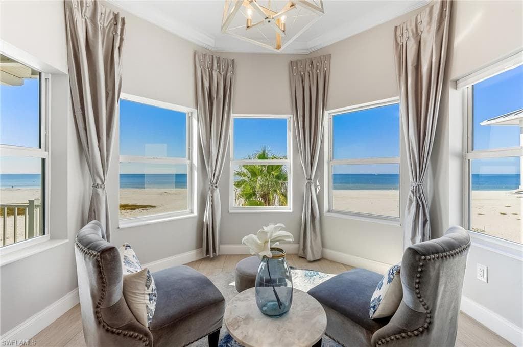 Sitting room featuring view of water and beach and plenty of natural light