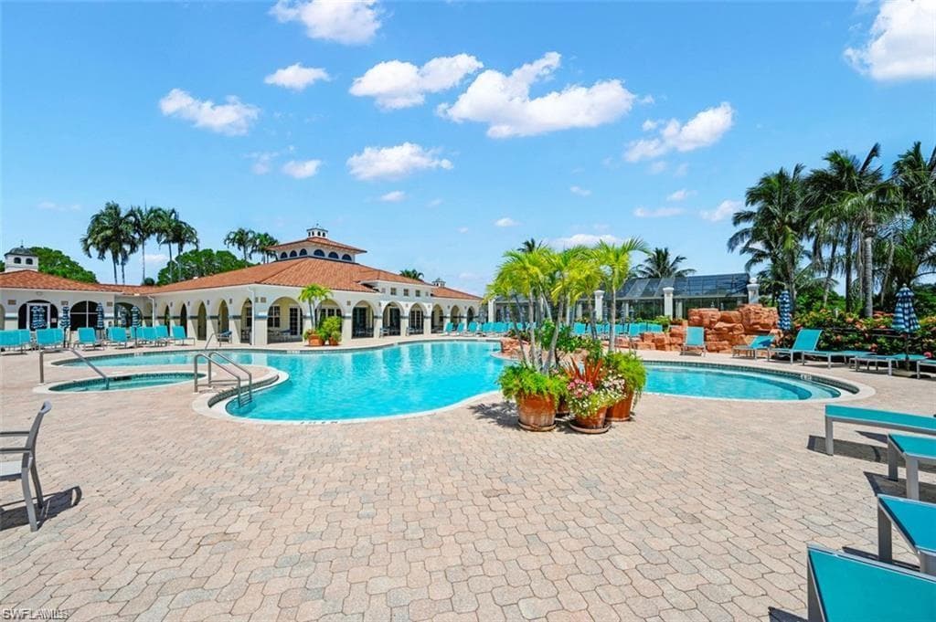 Community pool with a patio and a hot tub