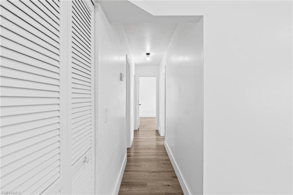Corridor with dark wood finished floors and baseboards