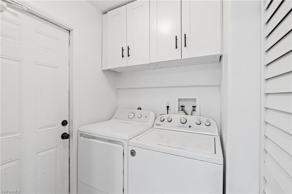 Laundry room featuring washing machine and clothes dryer and cabinet space