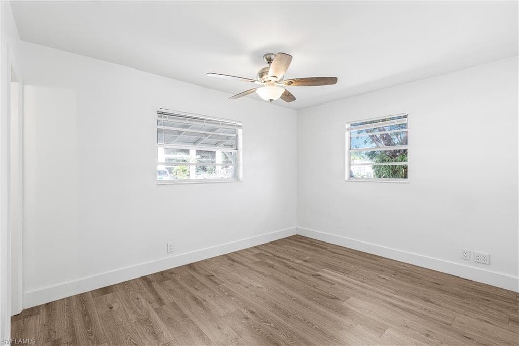 Spare room with wood finished floors and a ceiling fan