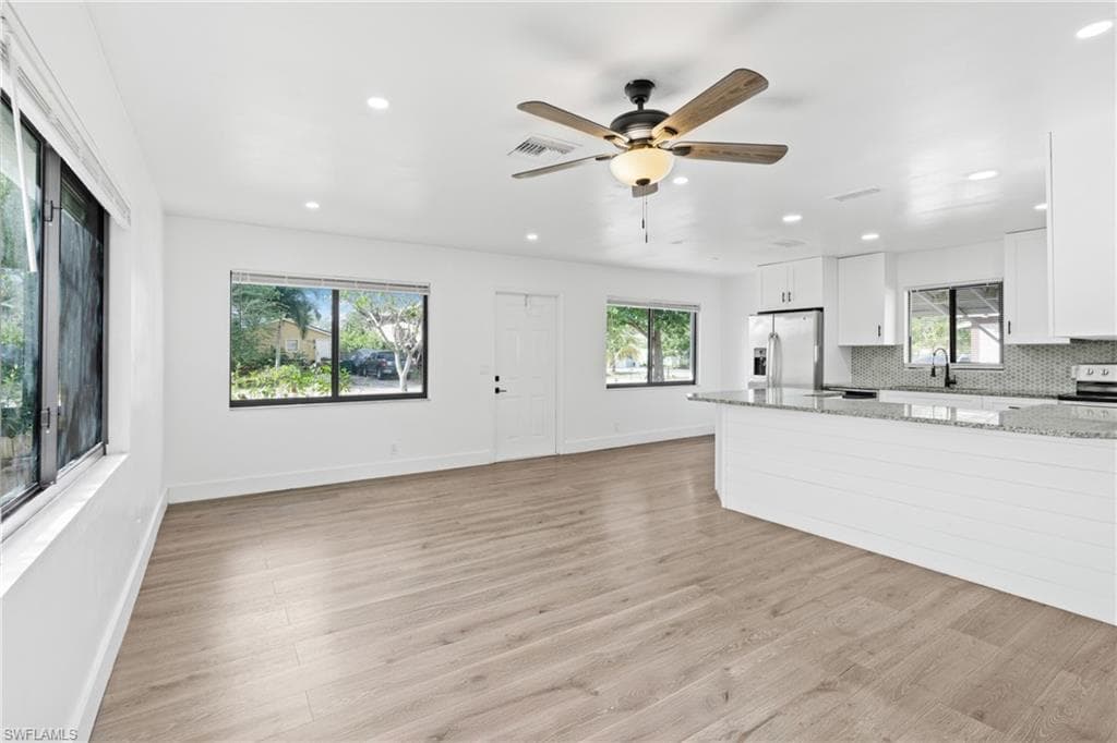 Unfurnished living room with light wood-type flooring, recessed lighting, and a ceiling fan