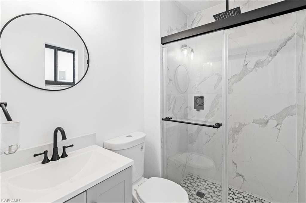 Full bath with vanity and a marble finish shower