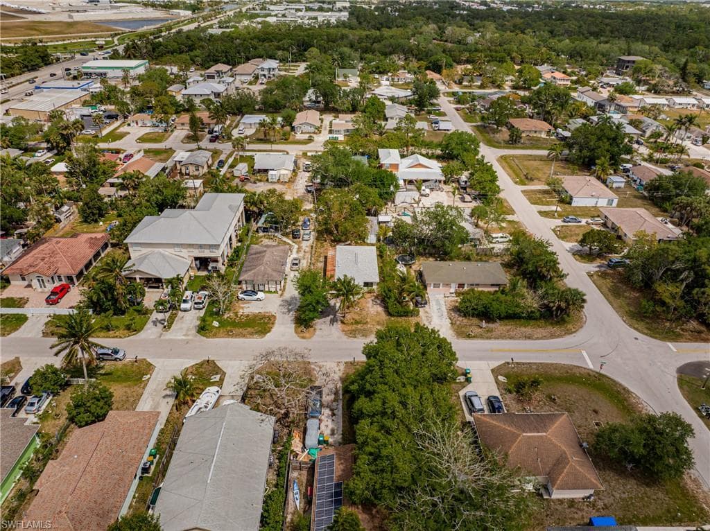 Aerial view of property and surrounding area featuring nearby suburban area