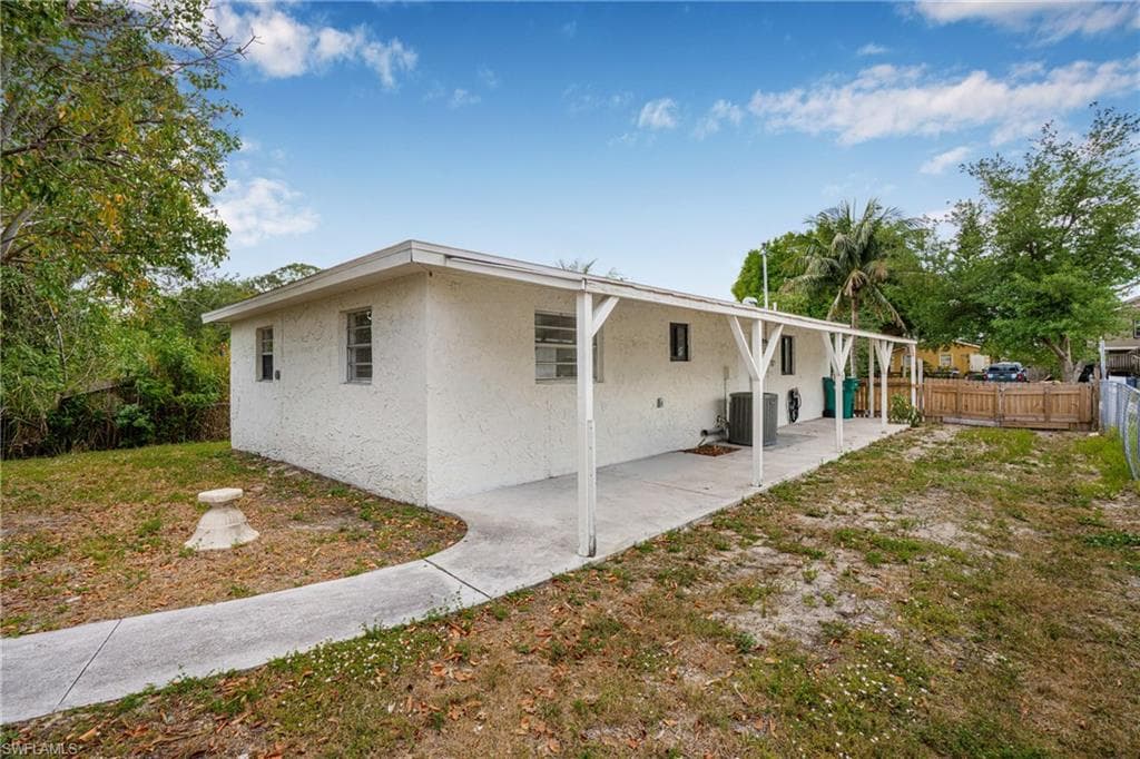 Back of house with stucco siding, a fenced backyard, and a patio area