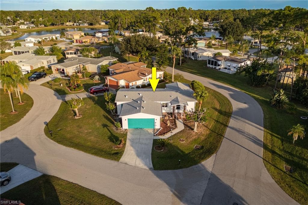 Aerial view of property and surrounding area featuring nearby suburban area and a nearby body of water