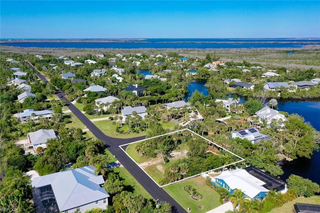Aerial view of residential area featuring a nearby body of water and property boundaries highlighted