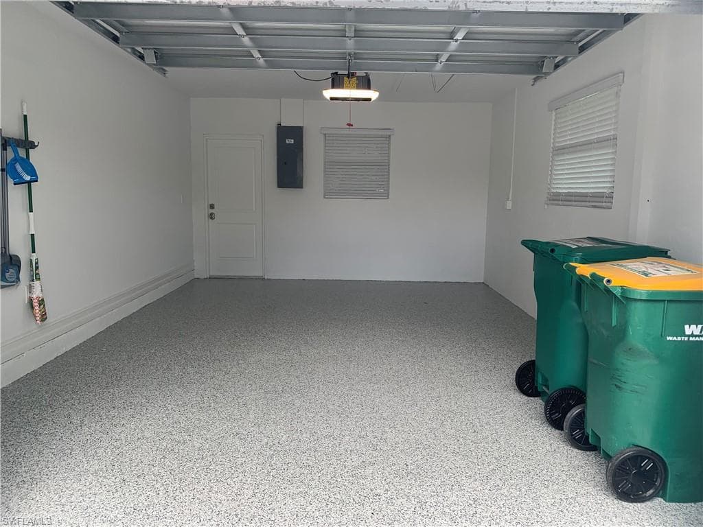 Garage featuring electric panel and a garage door opener