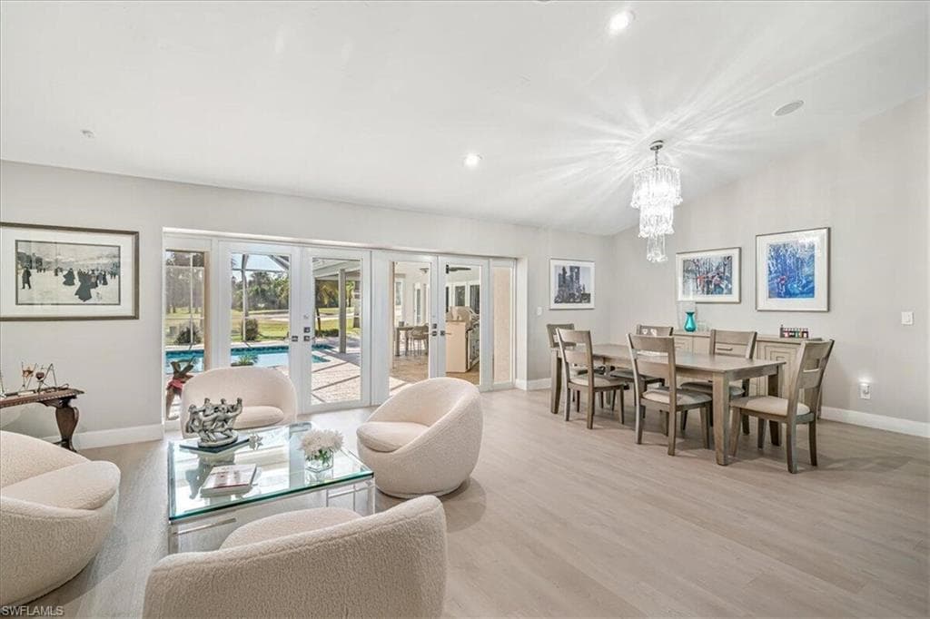 Dining area featuring french doors, light wood-style floors, recessed lighting, and a chandelier