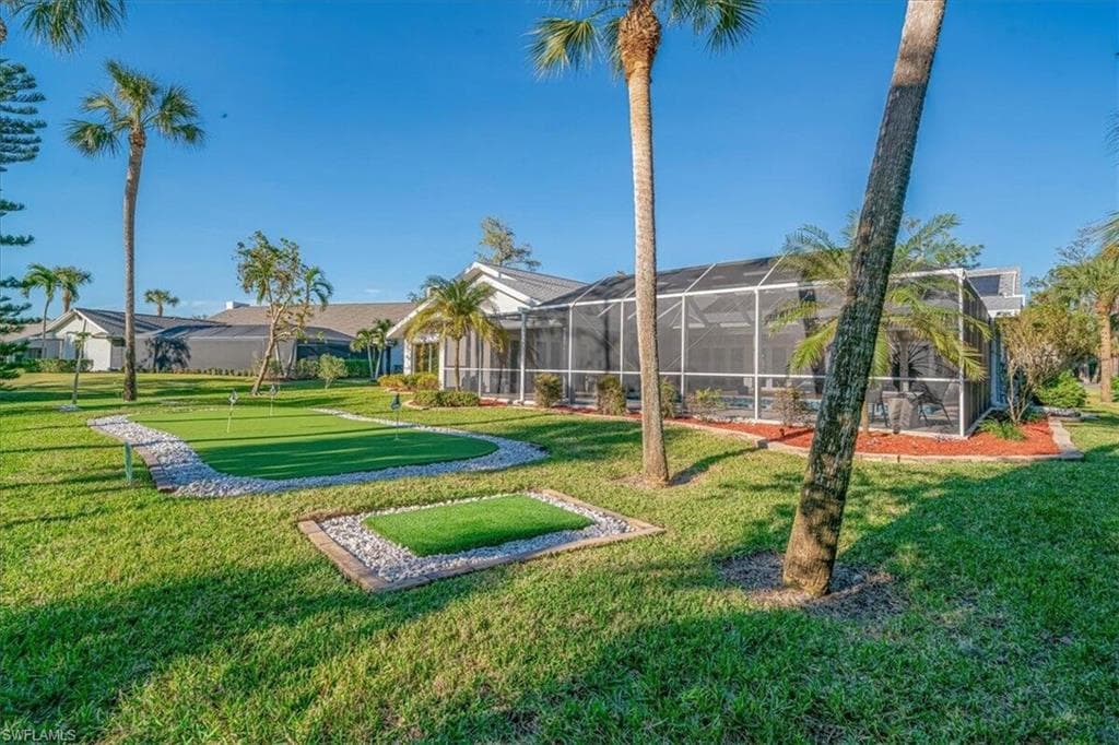 Surrounding community with a putting area, a sunroom, and a lawn