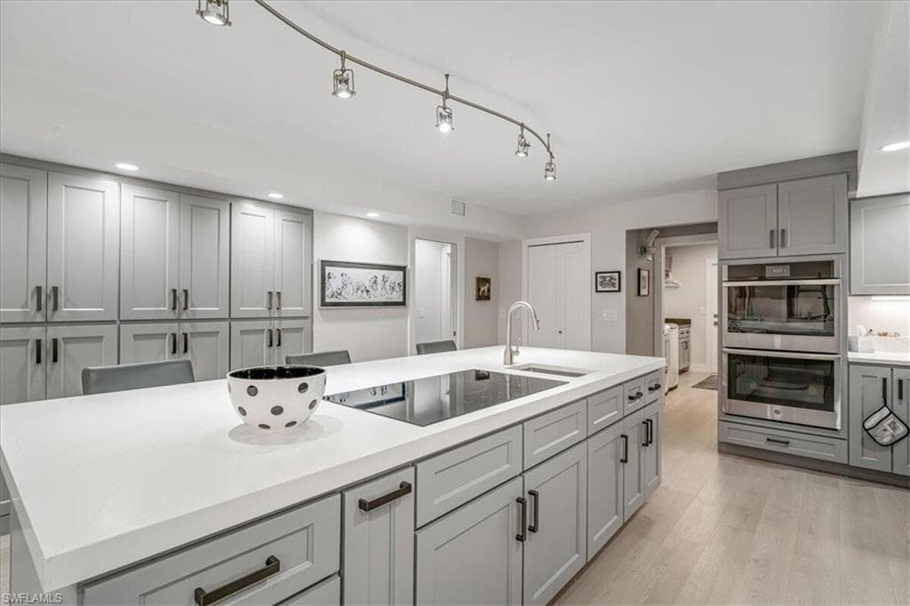 Kitchen featuring gray cabinetry, double oven, recessed lighting, black electric stovetop, and light wood-style flooring