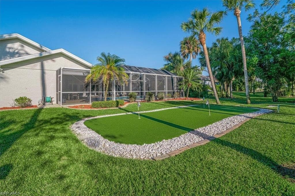 View of community featuring a putting area, a yard, and a sunroom
