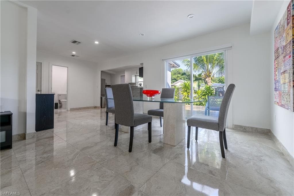 Dining space with recessed lighting and light marble finish floors
