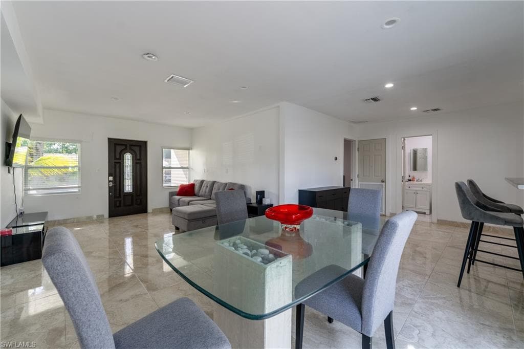 Dining room featuring recessed lighting and light marble finish floors
