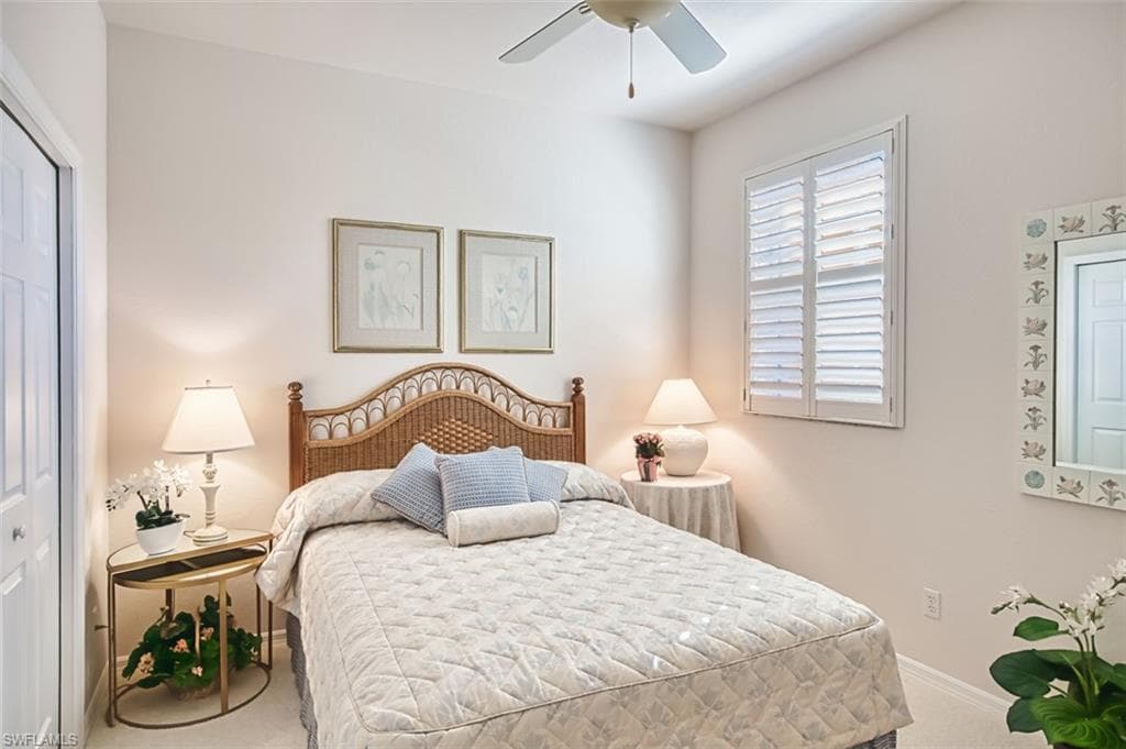 Carpeted bedroom with a closet and a ceiling fan