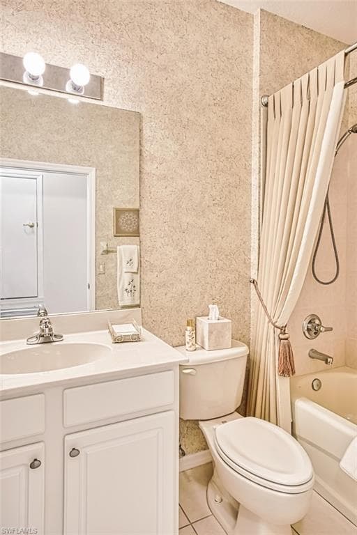 Full bath with light tile patterned floors, shower / bath combo, vanity, and wallpapered walls