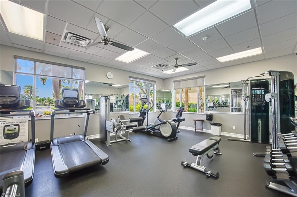 Gym with ceiling fan and a paneled ceiling