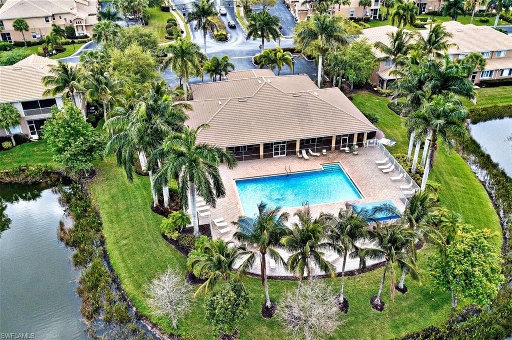 Aerial view of residential area with a pool area and a large body of water
