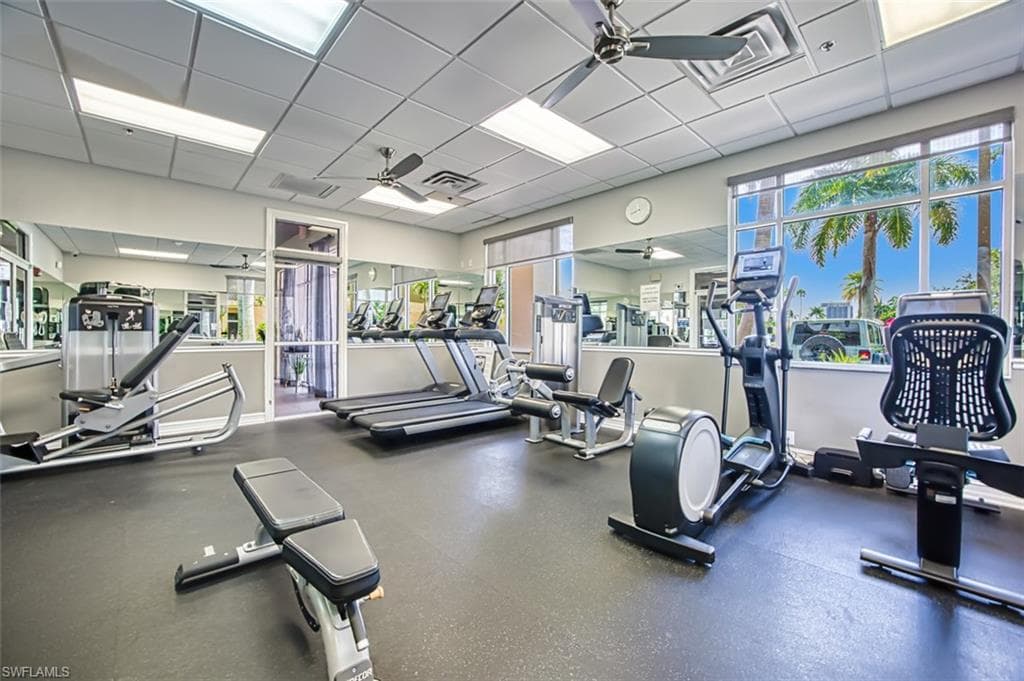 Workout area featuring a ceiling fan and a paneled ceiling