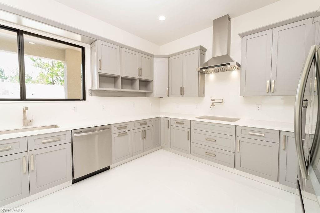 Kitchen with wall chimney range hood, appliances with stainless steel finishes, gray cabinetry, recessed lighting, and open shelves