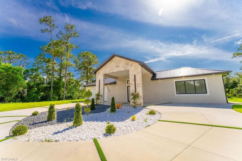 View of front of property featuring a metal roof and stucco siding