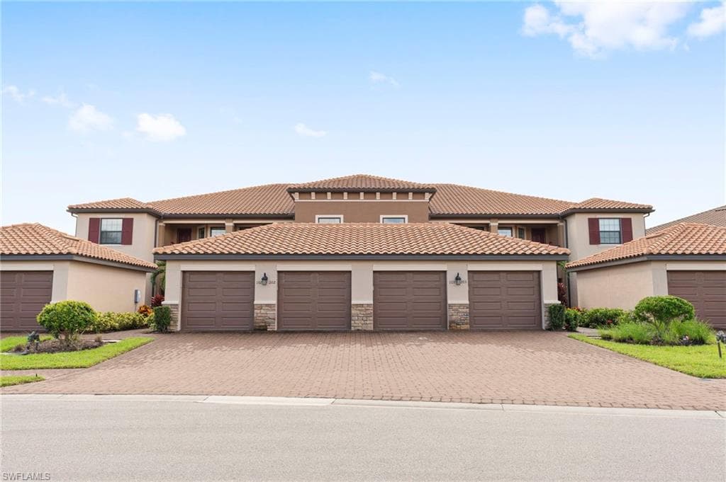 Mediterranean / spanish house featuring stucco siding, stone siding, and a tile roof