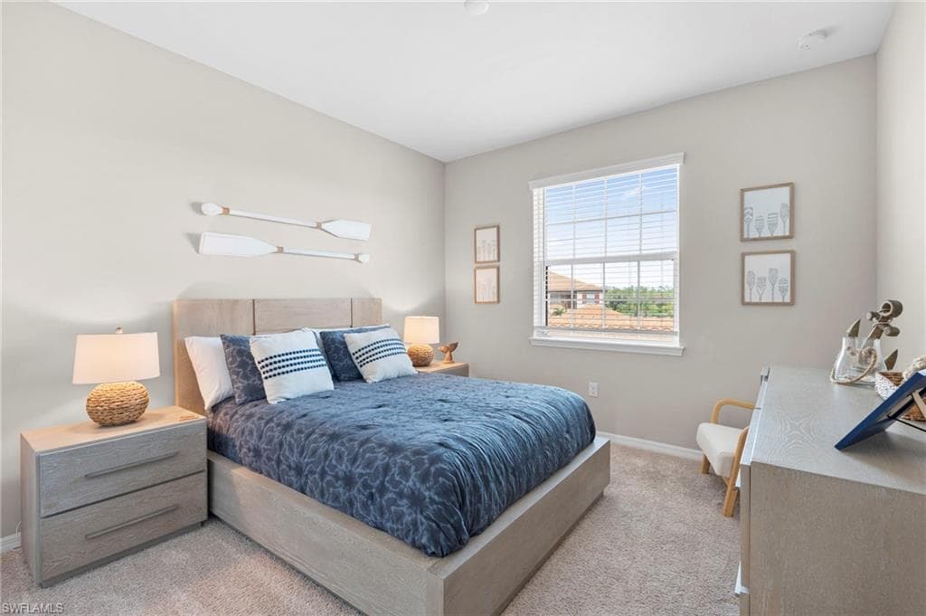 Bedroom with baseboards and light colored carpet