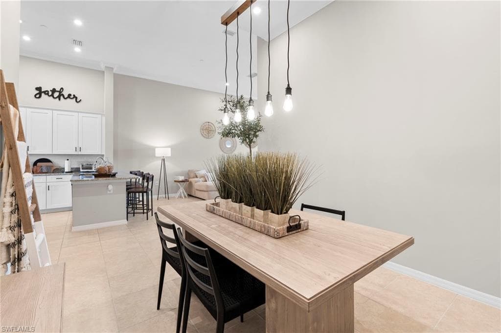 Dining area with light tile patterned floors and recessed lighting