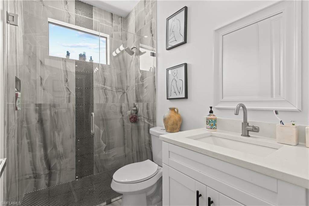 Full bathroom with vanity and a marble finish shower