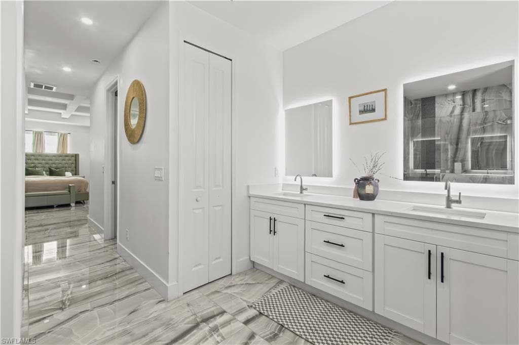 Bathroom with a closet, recessed lighting, double vanity, light marble finish floors, and a marble finish shower