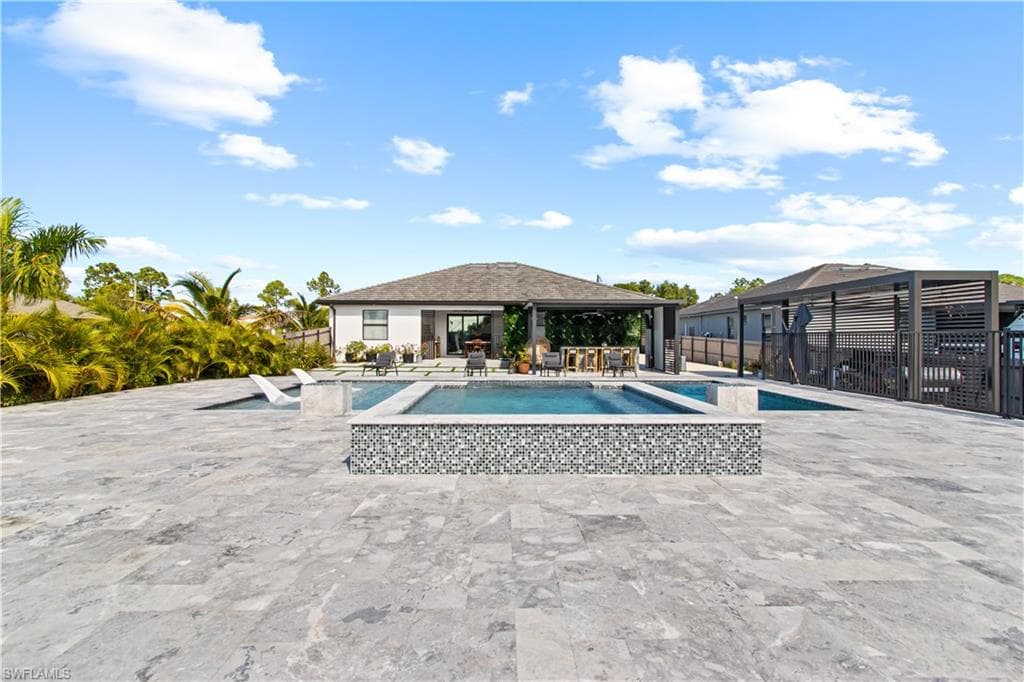 View of swimming pool featuring a patio area and a pool with connected hot tub